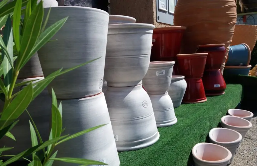 poteries de jardin grises et rouges exposées sur gazon synthétique avec plantes